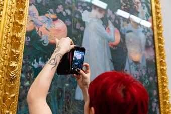 a close up of a person taking a photo of a painting